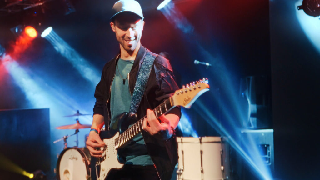 il chitarrista della band suona durante un concerto tributo ai Coldplay